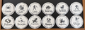 Set of 12 white zodiac round magnets / buttons with black text of the 12 zodiac signs with each button displaying different characteristics associated with each zodiac sign, on a dark background.