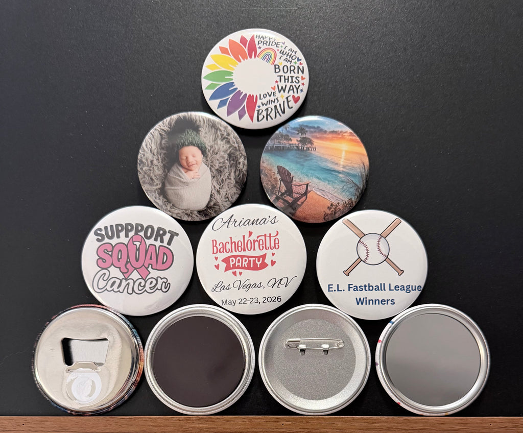 Collection of personalized pin buttons, magnets, pocket mirrors and metal bottle cap openers with various designs on a dark background surface.