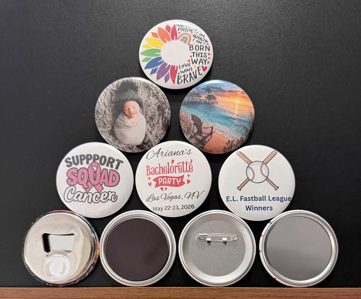 Collection of personalized pin buttons, magnets, pocket mirrors and metal bottle cap openers with various designs on a dark background surface.