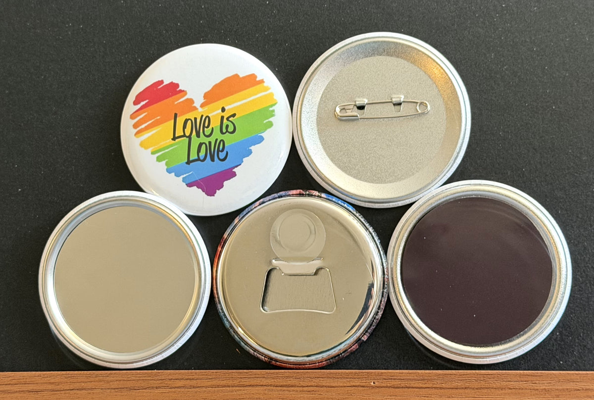 Round white magnet with a rainbow colored heart image with 'Love is Love' in black text.  Also in the photo are the four options available for this magnet which include a pin back button, pocket mirror, magnetic bottle opener and magnet.  This photo was photographed on a black background.