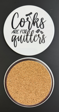 Round white drink coaster with cork backing with 'Corks are for quitters' in text black text, with black images of a corkscrew and wine corks photographed on a black background.