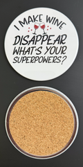 Round white drink coaster with cork backing with 'I make wine disappear, what's your superpower?' in black text and 2 glasses of red wine photographed on a black background.